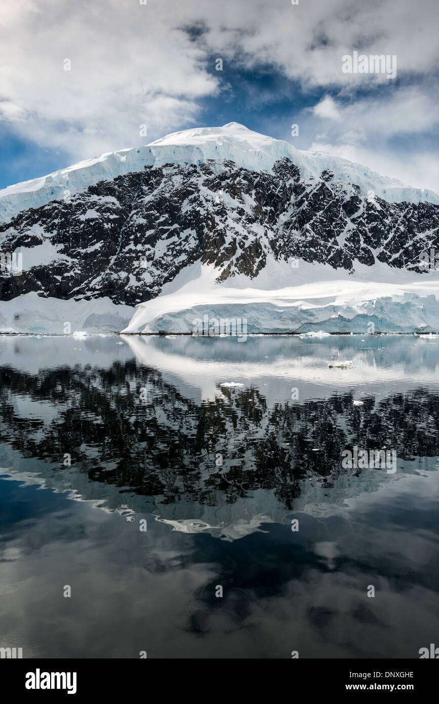 Neko Harbour Landscape Antarctic Peninsula Antarctica // NEKO HARBOUR, Antarctica—The icy and rocky scenic landscape mountains covered in ice and snow at Neko Harbour on the Antarctic Peninsula is reflected on glassy mirror-like calm waters. Stock Photo