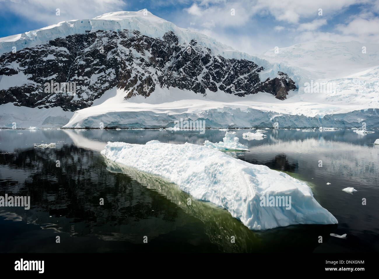 Neko Harbour Landscape Antarctic Peninsula Antarctica // NEKO HARBOUR, Antarctica—The icy and rocky scenic landscape mountains covered in ice and snow at Neko Harbour on the Antarctic Peninsula is reflected on glassy mirror-like calm waters. Stock Photo