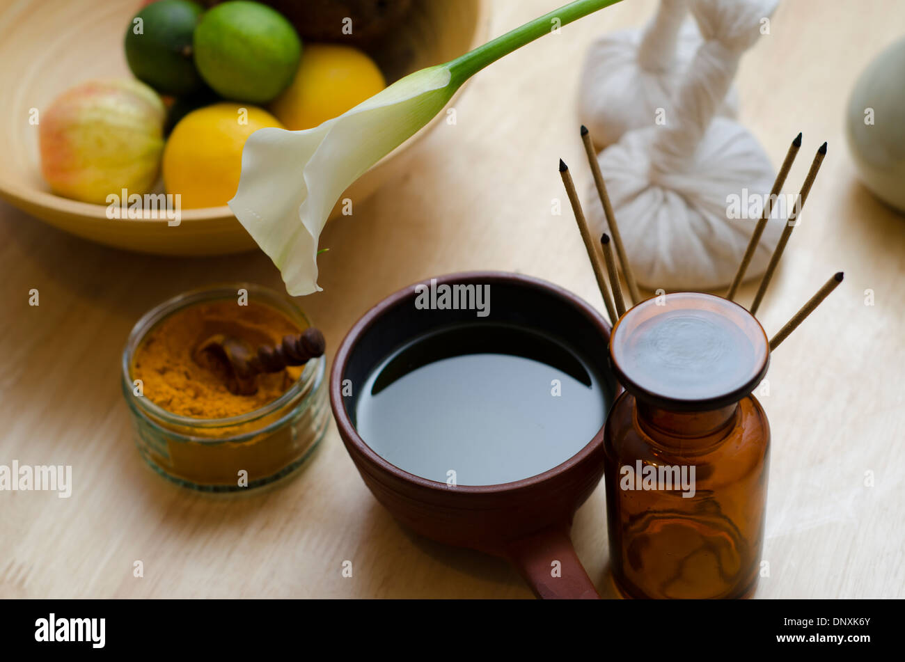 A countertop arrangement of ayurvedic turmeric spice, oil and massaging tools and an exotic flower used in Ayurveda massage. Stock Photo