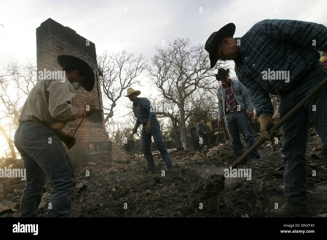 Dec 28, 2005; Cross Plains, TX, USA; Aaron Rogers, from left, Johnny Cleveland and Creath Switzer, all of Blanket, TX, help homeowner Allan Key, right, look for salvagable items in the remains of his home after a grass fire in Cross Plains, TX on Wednesday, December 28, 2005. Mandatory Credit: Photo by L. Krantz/San Antonio Express-News /ZUMA Press. (©) Copyright 2005 by San Antoni Stock Photo