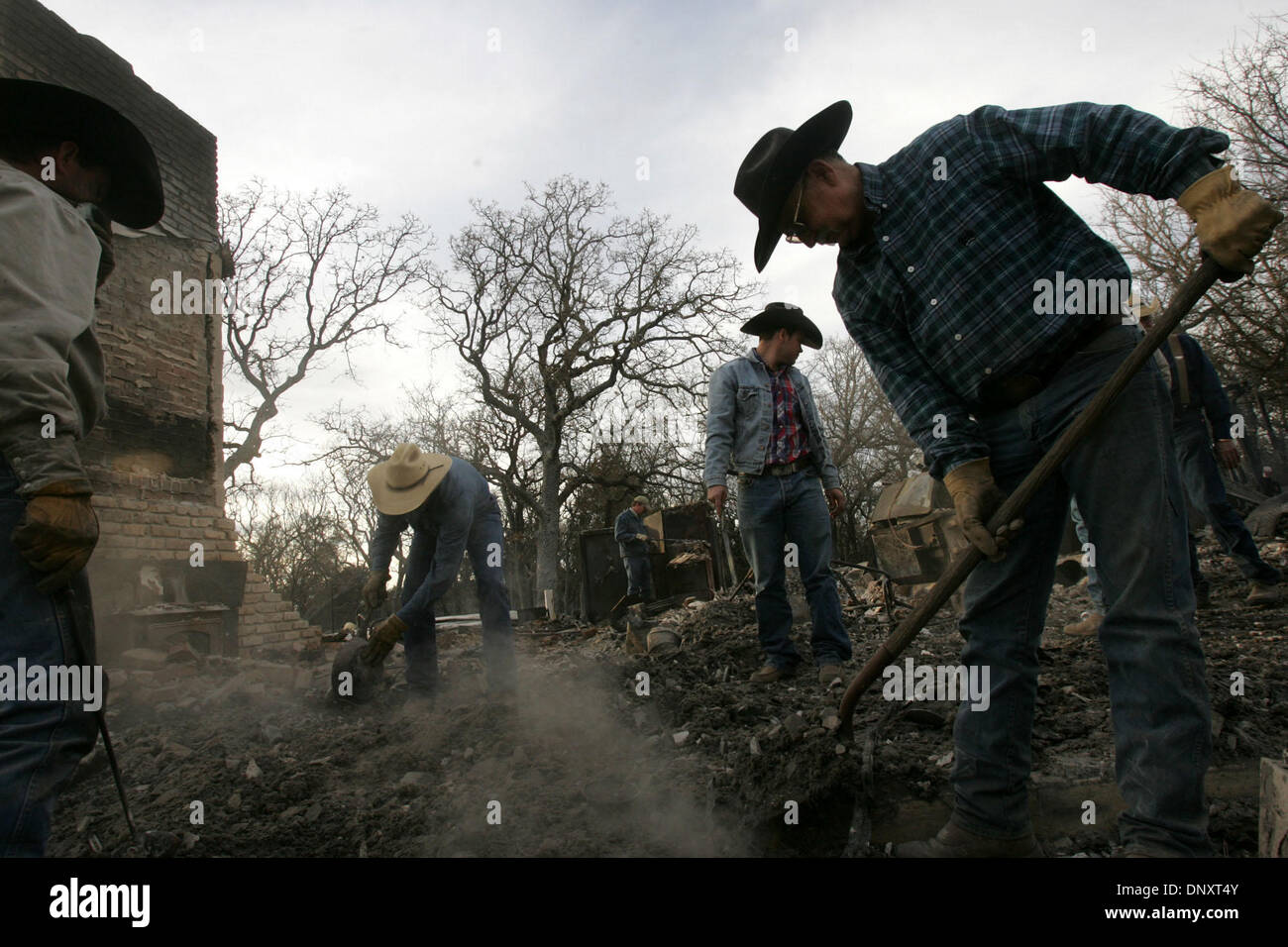 Dec 28, 2005; Cross Plains, TX, USA; Aaron Rogers, from left, Johnny Cleveland and Creath Switzer, all of Blanket, TX, help homeowner Allan Key, right, look for salvagable items in the remains of his home after a grass fire in Cross Plains, TX on Wednesday, December 28, 2005. Mandatory Credit: Photo by L. Krantz/San Antonio Express-News /ZUMA Press. (©) Copyright 2005 by San Antoni Stock Photo