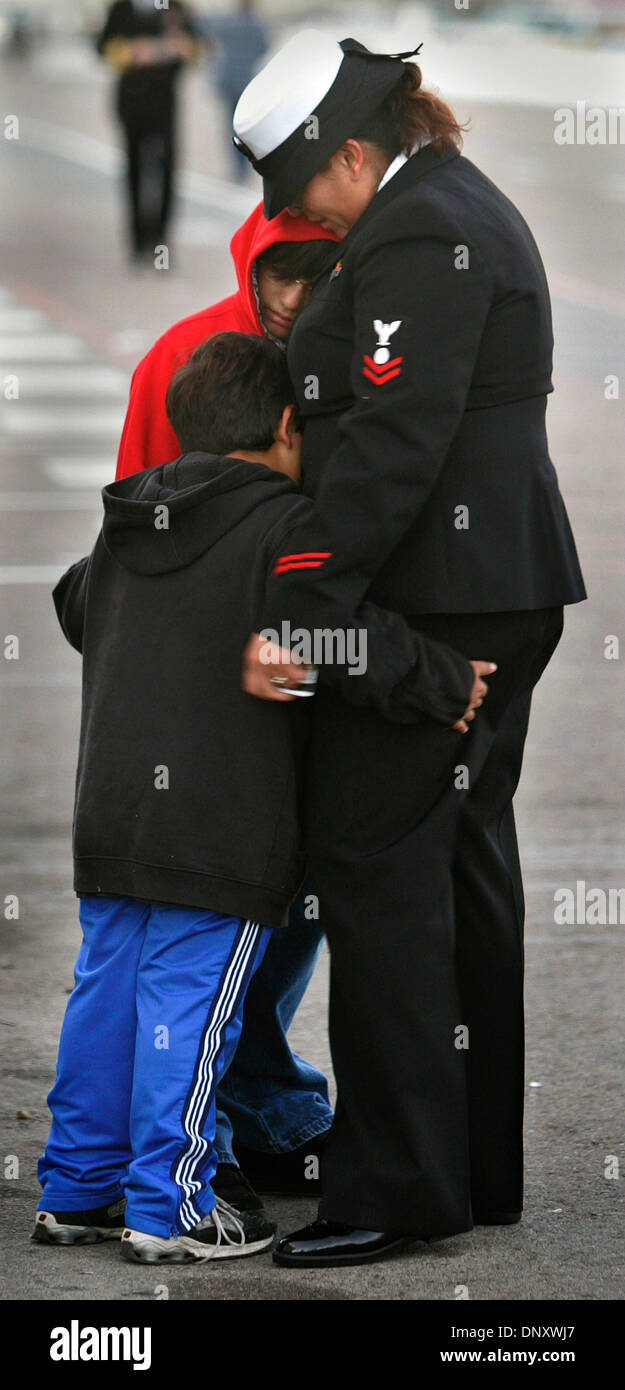 Jan 04, 2006; Coronado, CA, USA; MARIBEL TALLEY of Murphy Canyon, a USS Ronald Reagan crewmember hugs her children, JONATHAN TALLEY, 5, back to camera and JOSHUA TALLEY, 11, facing camera before leaving on the Reagan, the newest nuclear powered aircraft carrier in the U.S. Navy on its first West-Pac deployment which will include the Middle East in support of military operations in  Stock Photo