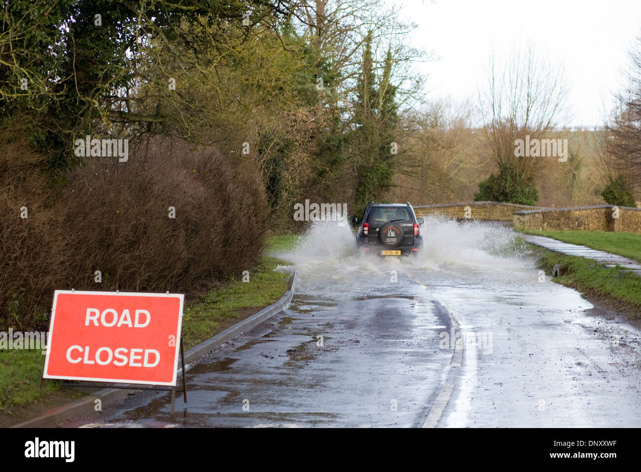 Driving through a Closed road Due to Flooding Ignoring Advise from Sign Stock Photo