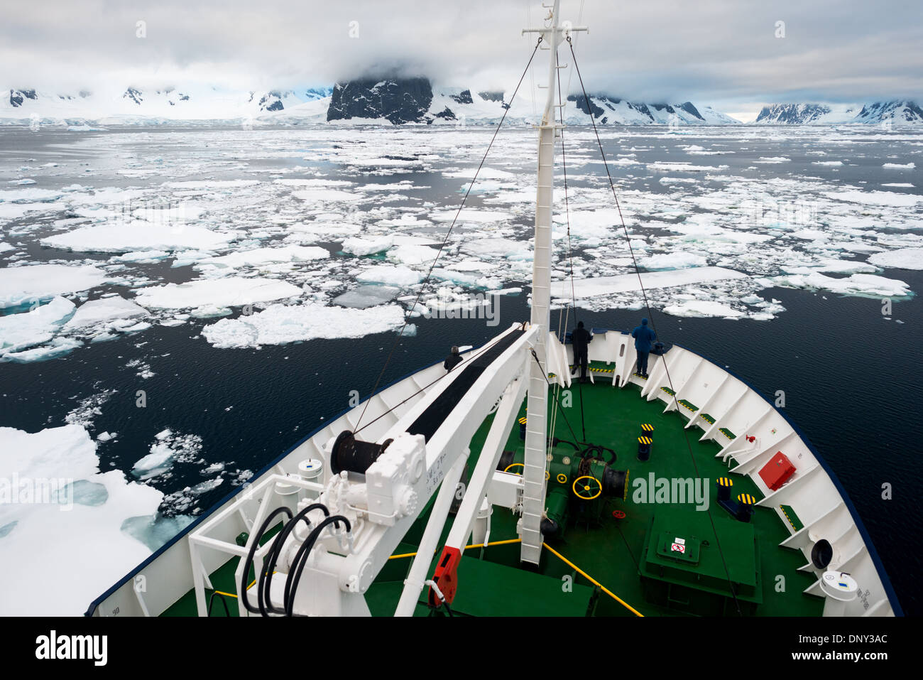 ANTARCTICA - An ice-strengthened ship pushes through the sea ice at the northern end of the Lemaire Channel along the Antarctic Peninsula. Stock Photo