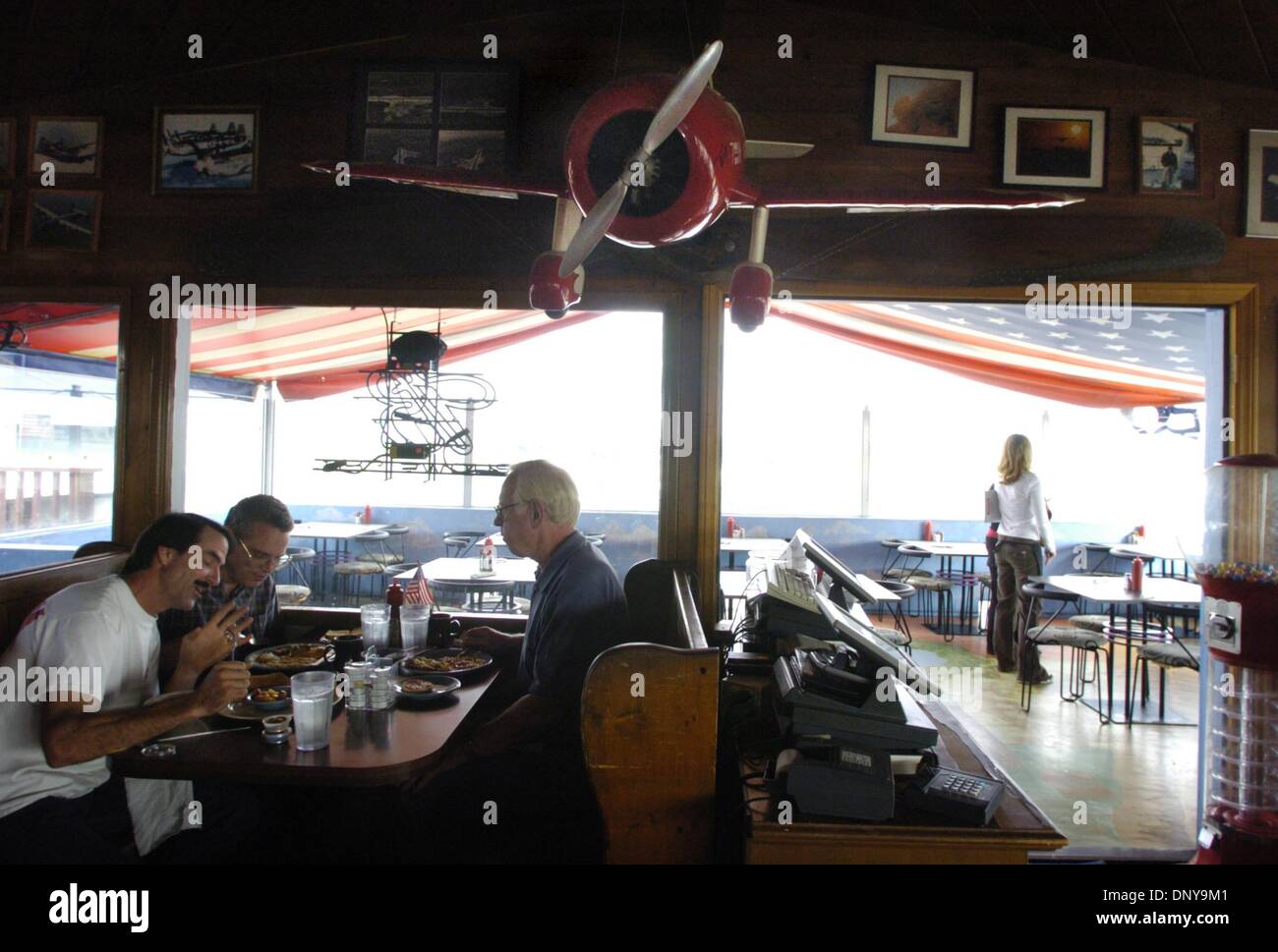 (PUBLISHED 10/6/2004, NC-1, NI-1)  NSAirprtCafeEnd228826x002 - shot 10/1/04 - Patrons of the Palomar Airport Cafe: Jeff Grismer, far left, of San Marcos; Darrell Fillpot of La Ceiba, Honduras; and Johan Pettersen (CQ), enjoy breakfast together, a regular ritual at the restaurant for the men, Friday morning.  The cafe is being dismantled, while it serves its last meals from its loca Stock Photo