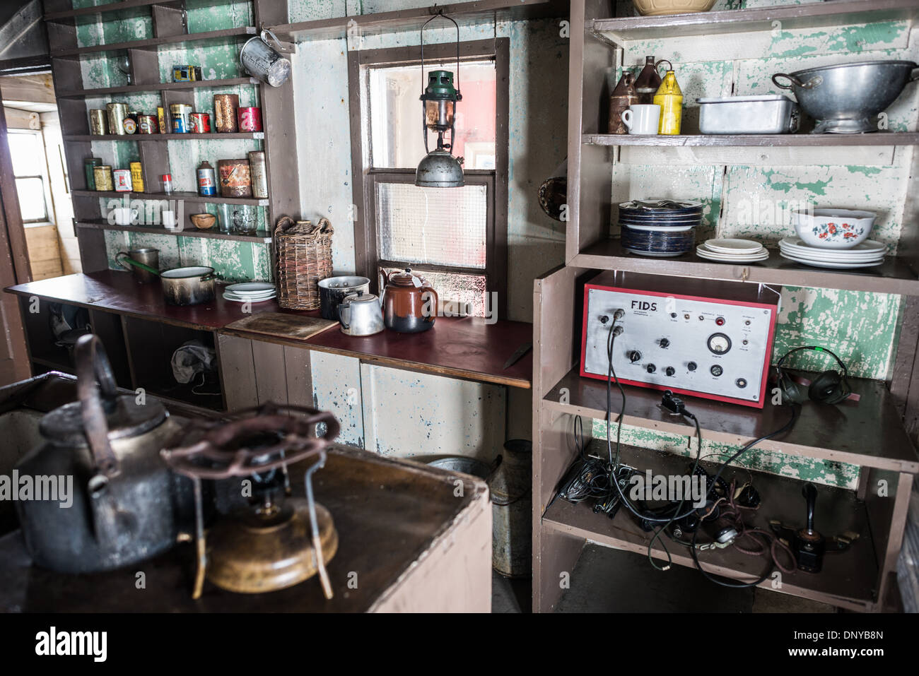 Wordie House Kitchen Radio Antarctica // WINTER ISLAND, Antarctica — The kitchen area of Wordie House, featuring a large radio with the acronym FIDS for Falkland Islands Dependency Survey. Originally established in 1947 as Base F by the Falkland Islands Dependencies Survey, the successor organization to Operation Tabarin, and later renamed after James Wordie, chief scientist and geologist on Ernest Shackleton's Endurance expedition, this research station is preserved near Vernadsky Research Base in the Argentine Islands. Stock Photo