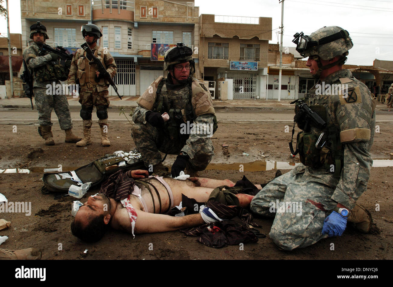 Jan 26, 2006; Abu Ghraib, Baghdad, IRAQ; American soldiers look after a wounded insurgent in Baghdad on Jan. 26, 2006. The insurgent was shot 20 times during a gun battle between American soldiers and a car of four insurgents. Iraqi Ministry of Defense identification cards and drug-filled syringes were found in the car along with four AK-47s, one PKM machine gun, one RPG launcher,  Stock Photo