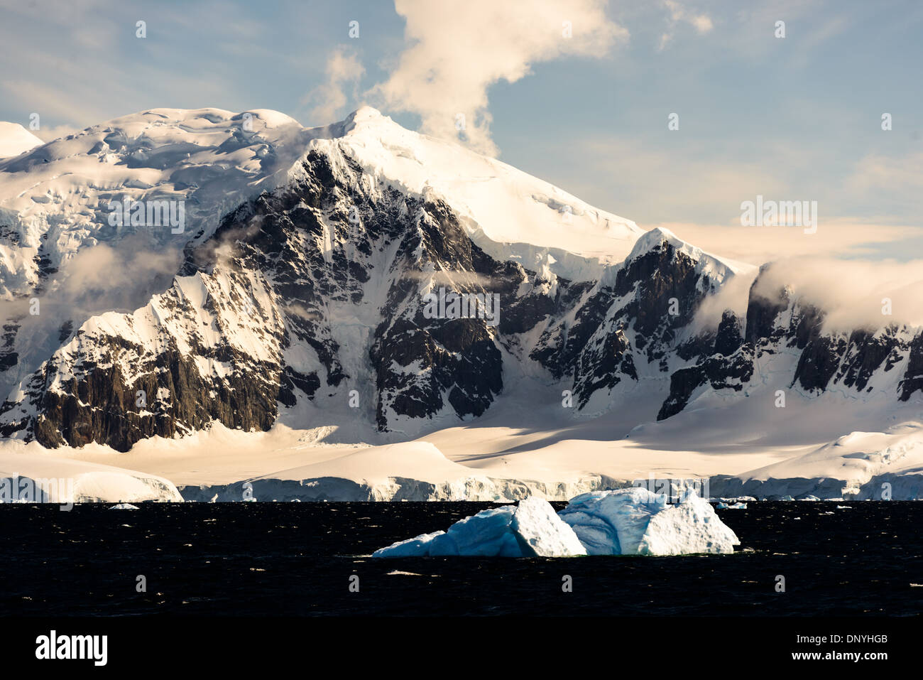 ANTARCTICA - Dramatic snow and ice-covered mountains rise up from the shoreline of the Gerlacht Strait on the western coast of the Antarctic Peninsula. Stock Photo
