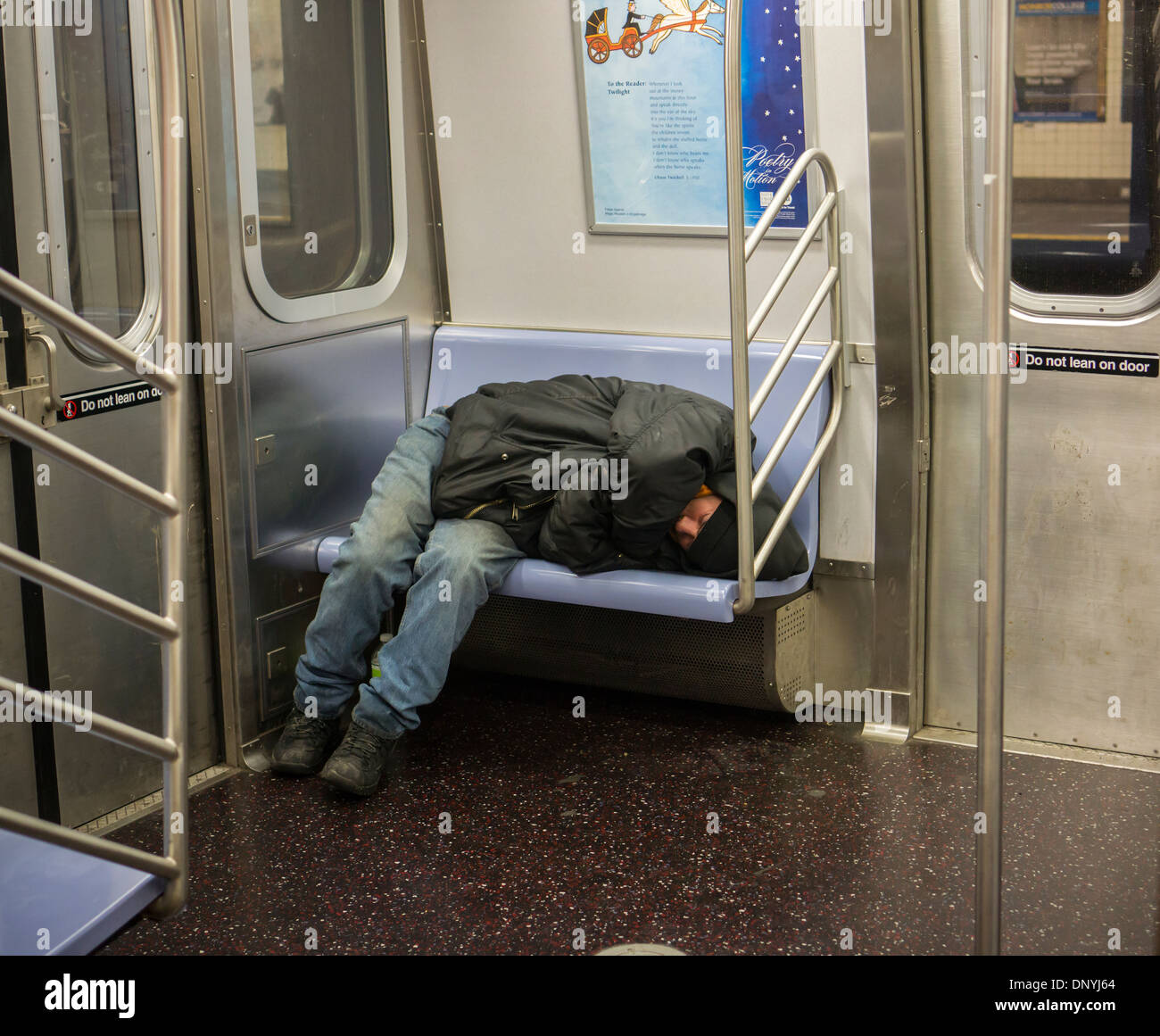Homeless man takes up several seats as he sleeps in a subway car in New York on Monday, January 6, 2014. (© Richard B. Levine) Stock Photo