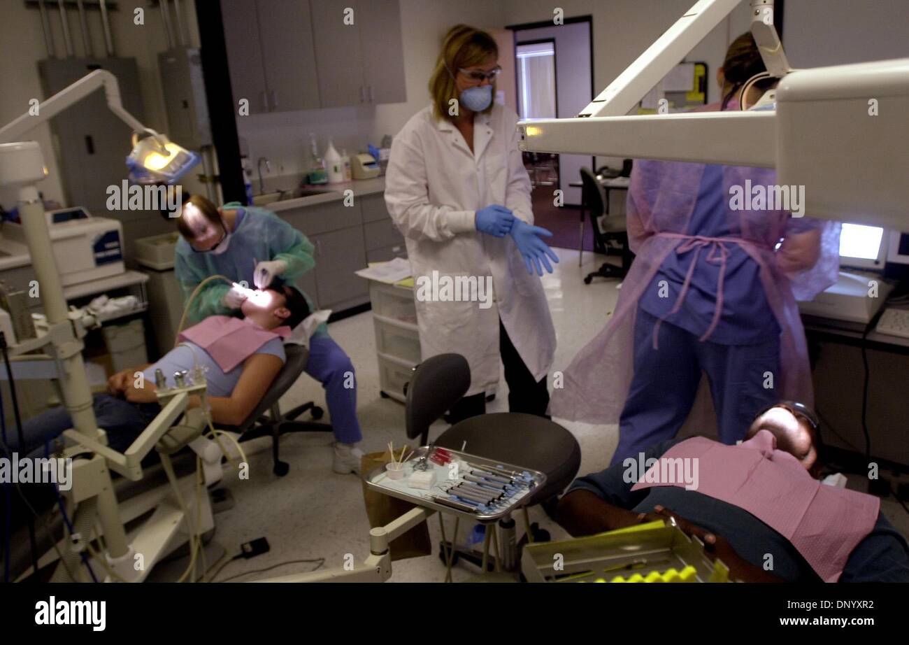 (Published 8/5/2004, B-10:1, B-14:2, B-6:6,7, UTS1823729)The dental hygiene clinic operated by Southwest College in National City offers free cleaning to patients who agree to be worked on by students like Diane Andon, left, working on Jaqueline Barmbita; and Jessica Sill, back to camera right, looking at the x-rays of patient Gregory Otis. In the white coat, center, putting on glo Stock Photo