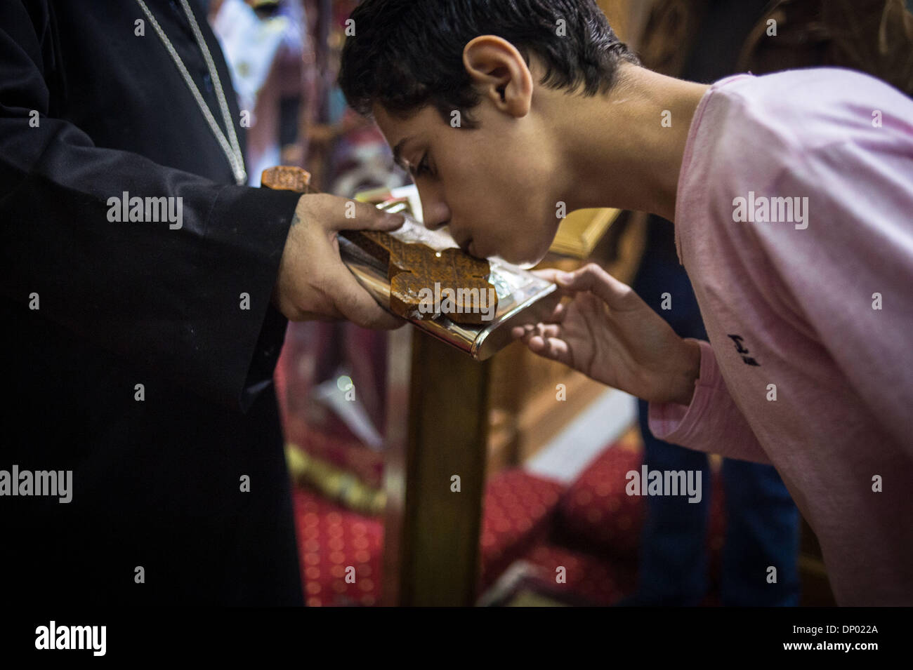 Cairo, Egypt. 7th Jan, 2014. A Coptic Christian kisses the cross when he attends the Coptic Christmas Eve mass at the Abo Sefen church in the Maadi district of Cairo, capital of Egypt, on Jan. 6, 2014. Coptic Orthodox Christmas falls on Jan. 7, when Egypt's Copts, who make up 10 percent of the Egyptian population, celebrate the feast. Credit:  Pan Chaoyue/Xinhua/Alamy Live News Stock Photo