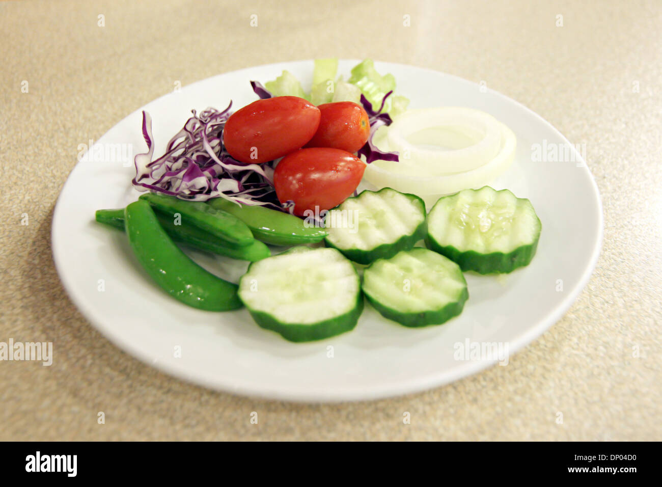 Tomato and cucumber placed on white dish. Stock Photo
