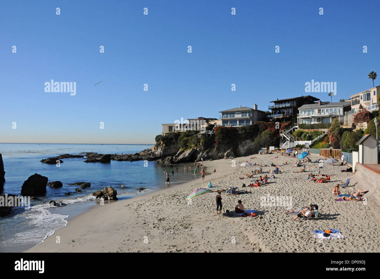 Coastal homes and sun bathers at Woods Cove in Laguna Beach on a warm winter day in  Southern California Stock Photo