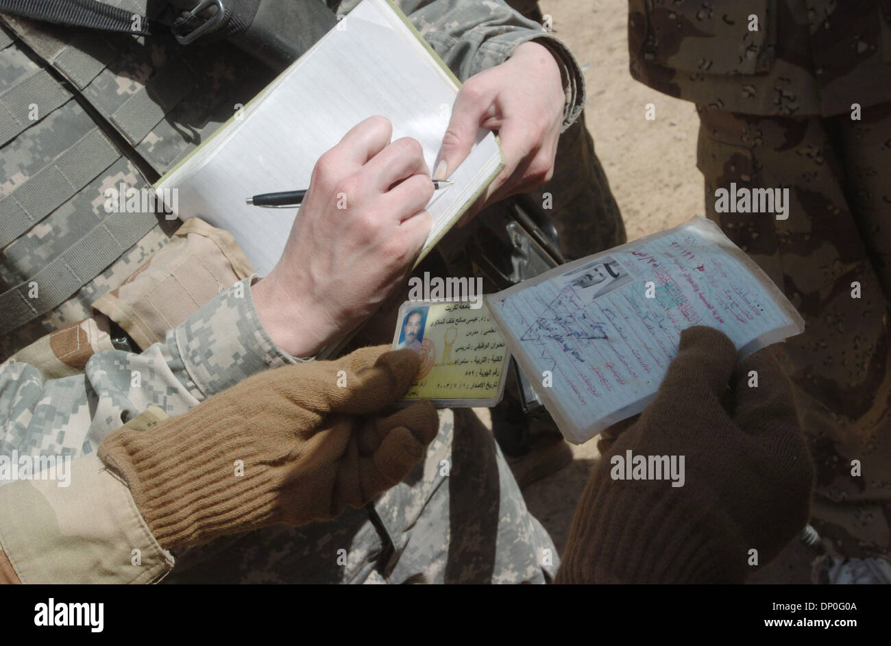 Mar 18, 2006; Saluhiddin, IRAQ; Soldiers from Troop C, 2-9 Cavalry match identification cards of a suspected insurgent during Operation Swarmer March 18, 2006. The man, allegedly the cavalry squadron's most wanted insurgent, and one of his brothers was later detained. Nearly 1,500 US and Iraqi soldiers, 50 attack and transport helicopters and 200 ground vehicles were out during the Stock Photo