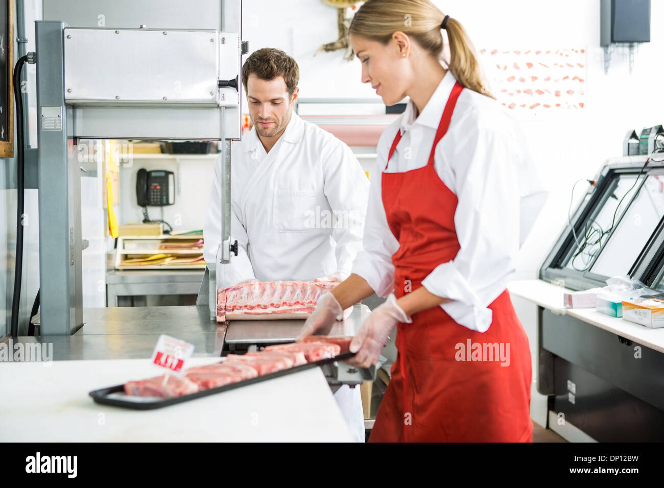 Butchers Processing Meat In Store Stock Photo Alamy