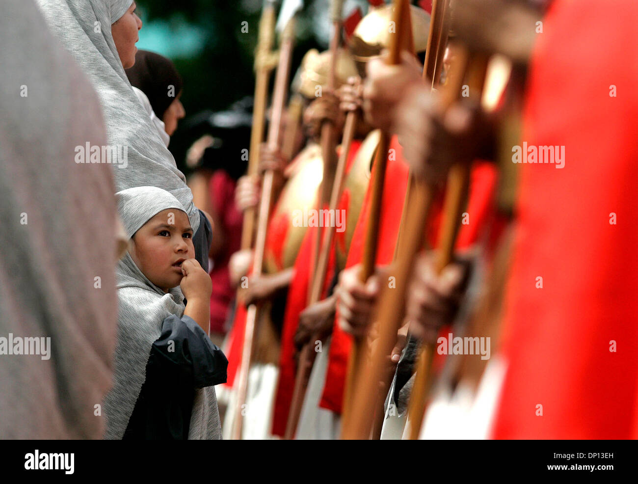 Apr 14, 2006; San Antonio, TX, USA; A child portraying a villager stands before a row of armed roman guards during San Fernando Cathedral's annual Via Crucis in Milam Park in San Antonio. Mandatory Credit: Photo by Mike Kane/ZUMA Press. (©) Copyright 2006 by San Antonio Express-News Stock Photo