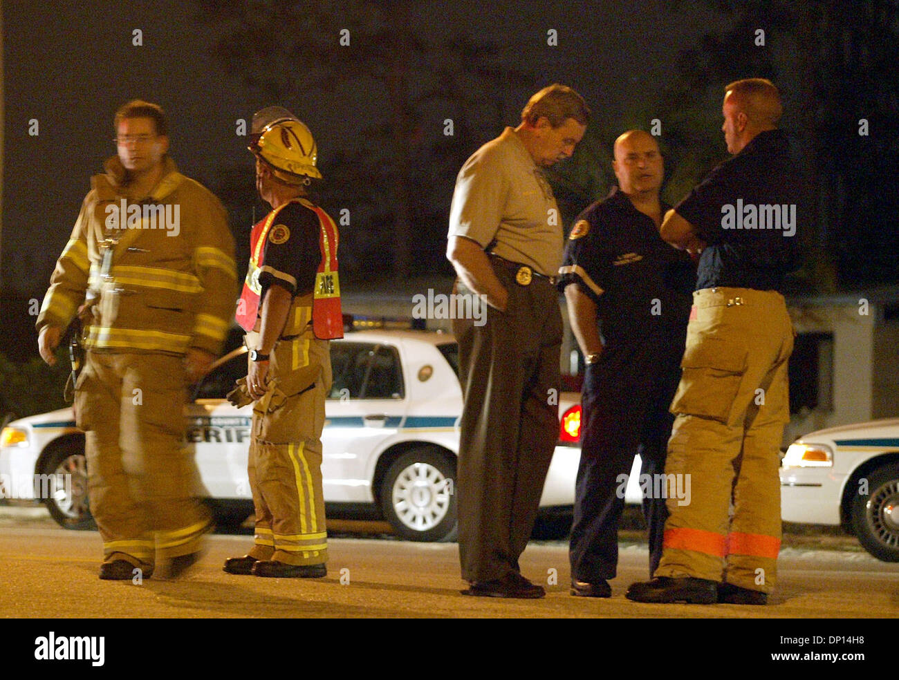Apr 18, 2006; Boynton Beach, FL, USA; Palm Beach County Sheriff Ric Bradshaw, middle, and Fire-Rescue officials stand on Hypoluxo Blvd. just east of Jog Rd. waiting to set up a command post after a house on Hypoluxo Farms Rd. exploded Tuesday evening, April 18, 2006 in suburban Boynton Beach. Sheriff's Office personnel blocked off numerous side streets to keep bystanders back. The  Stock Photo