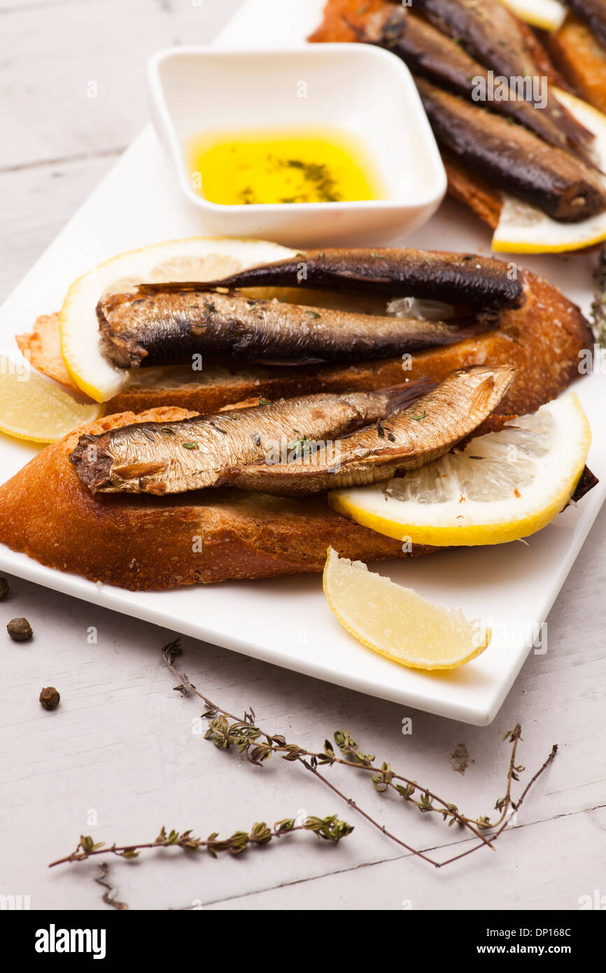 Fish, Spanish tapas - sprat with lemon on baked bread Stock Photo