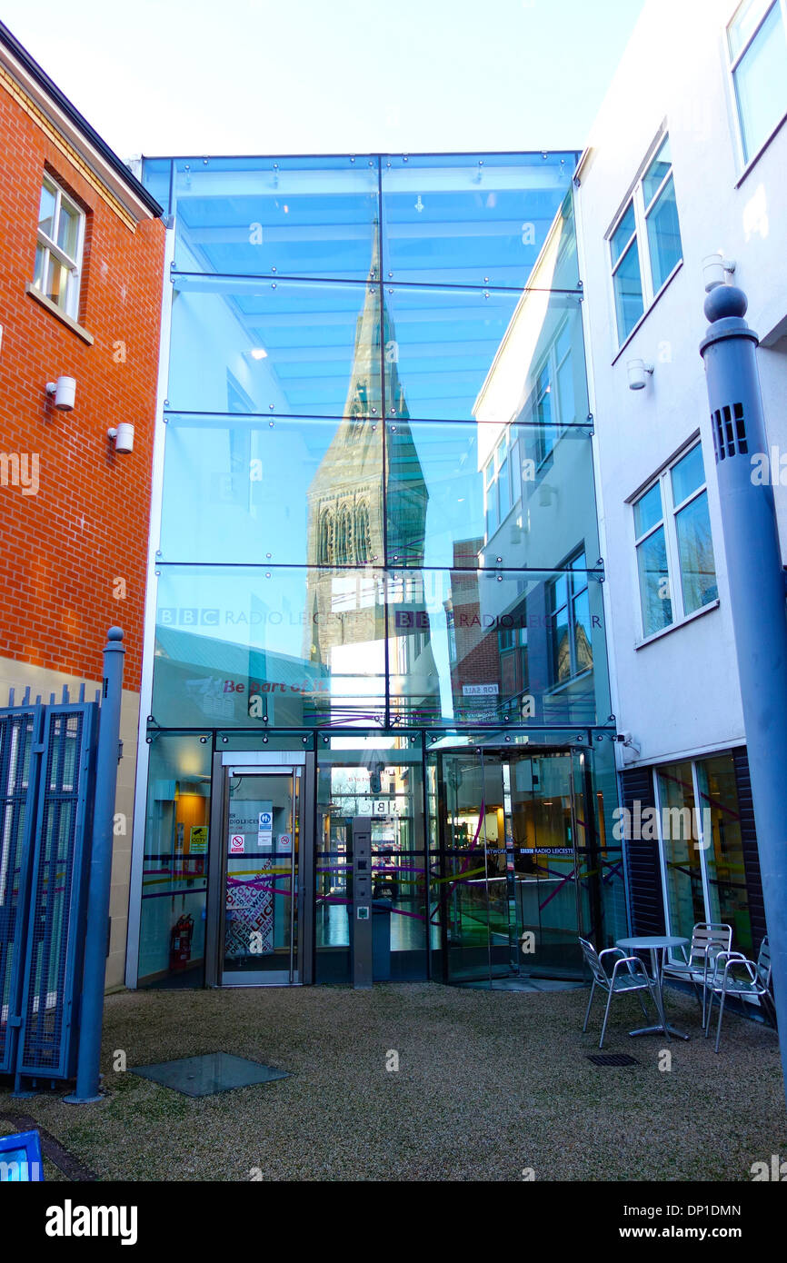 The entrance to BBC Radio Leicester with the spire of Leicester Cathedral reflected in the glass front