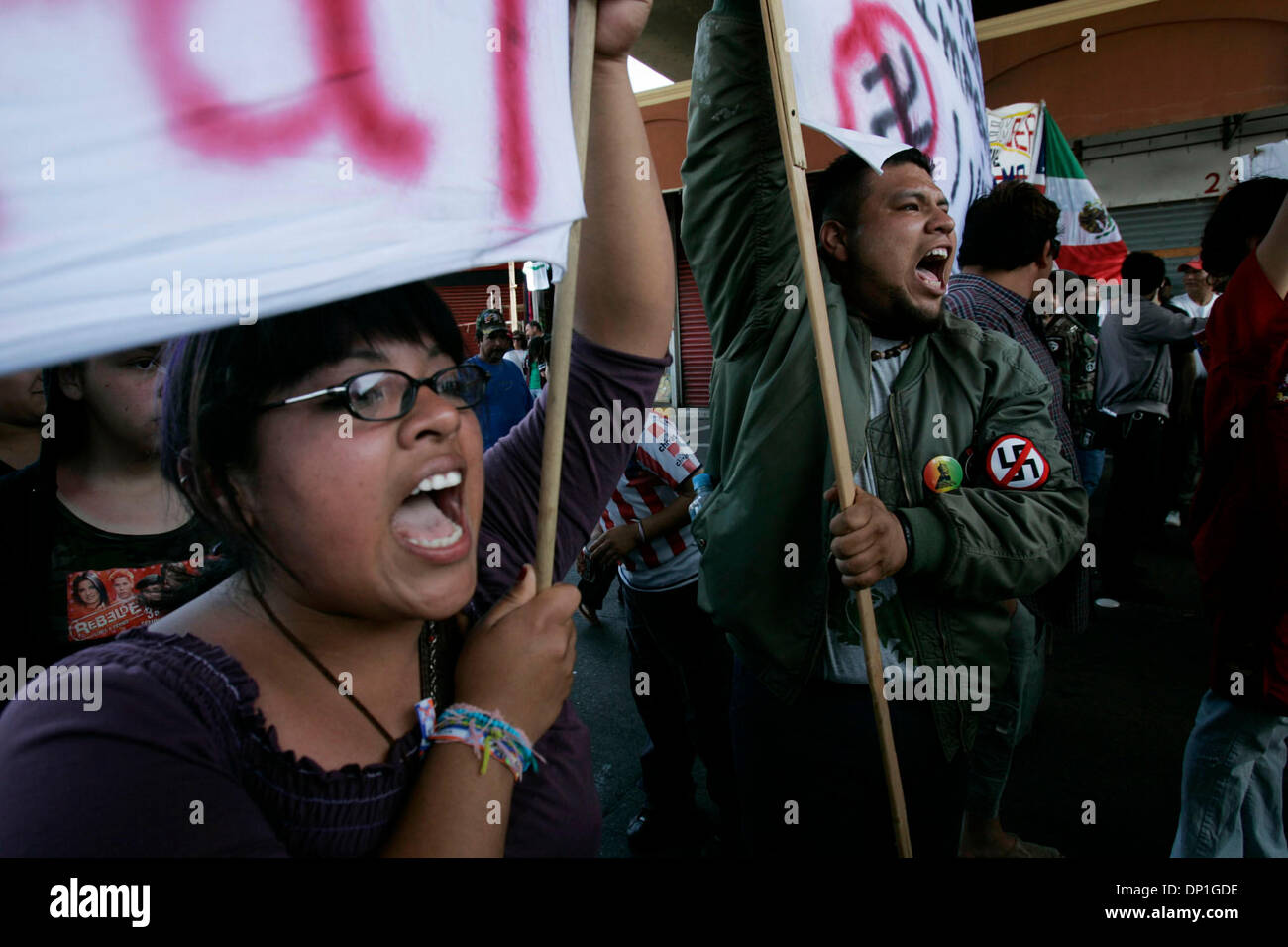 May 01, 2006;  Lakeside, CA, USA; DANIA SOTO, left, and ROJO MARCOS, right, yell protest chants at the cars stopped by their group at the border in Tijuana. Hundreds of protesters formed  a human chain across northbound lanes at the San Ysidro border crossing Monday to stop fellow Mexicans from going to jobs or shopping in San Diego. Police had to push the protesters to to the side Stock Photo