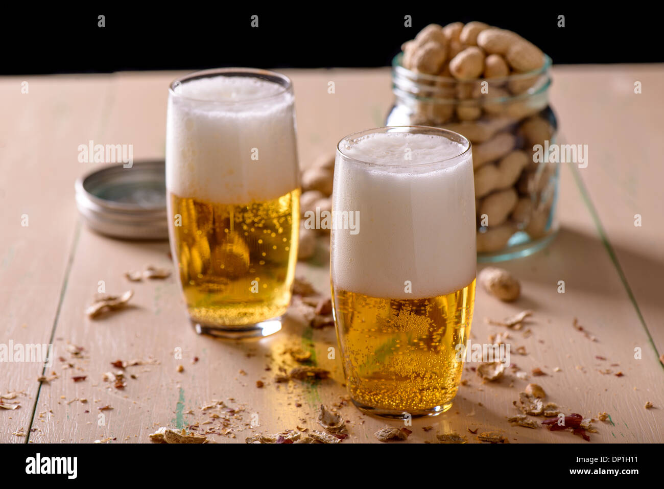 Beer with peanuts on old wood table Stock Photo