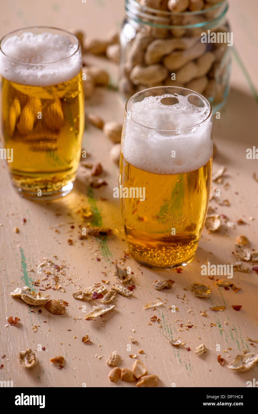 Beer with peanuts on old wood table Stock Photo