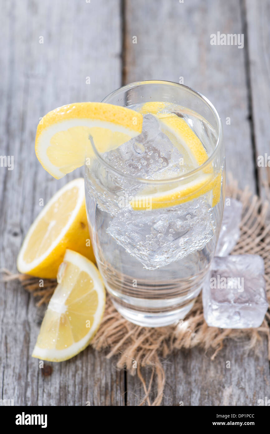 Sparkling Water with Lemon and ice on wooden background Stock Photo - Alamy