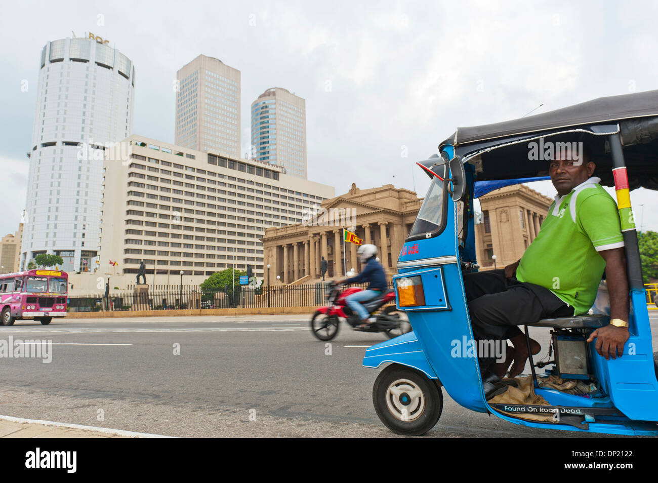 Tuk tuk driver with the building of the Bank of Ceylon at the back, the Old Parliament, right, Colombo, Sri Lanka Stock Photo