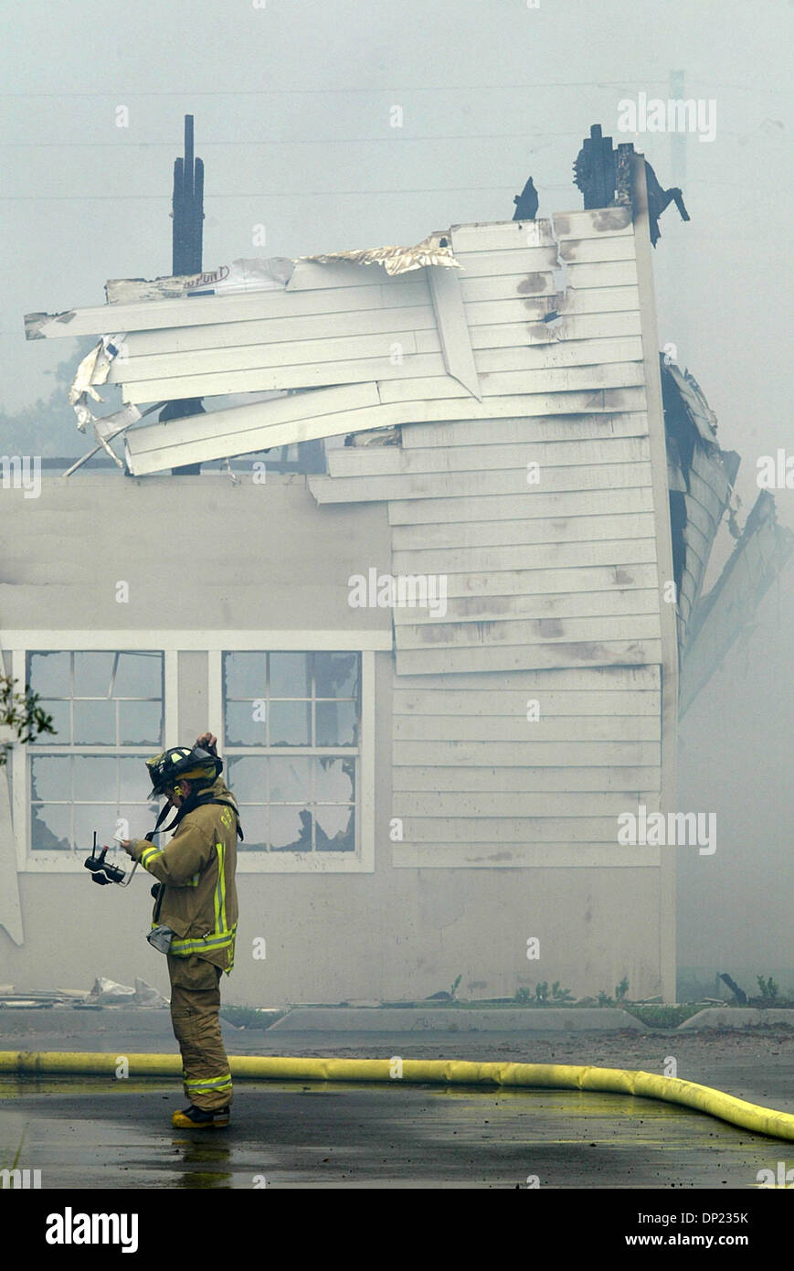 May 16, 2006; Boca Raton, FL, USA; A Boynton Beach firefighter pulls off gear as the T-3 building on the Boca Raton Florida Atlantic University campus burns to the ground Tuesday, May 16, 2006. Units from Boca Raton, Delray Beach, Boynton Beach, Palm Beach County and Deerfield Beach responded to the blaze. The building dates from World War II when it was used to house radar technic Stock Photo