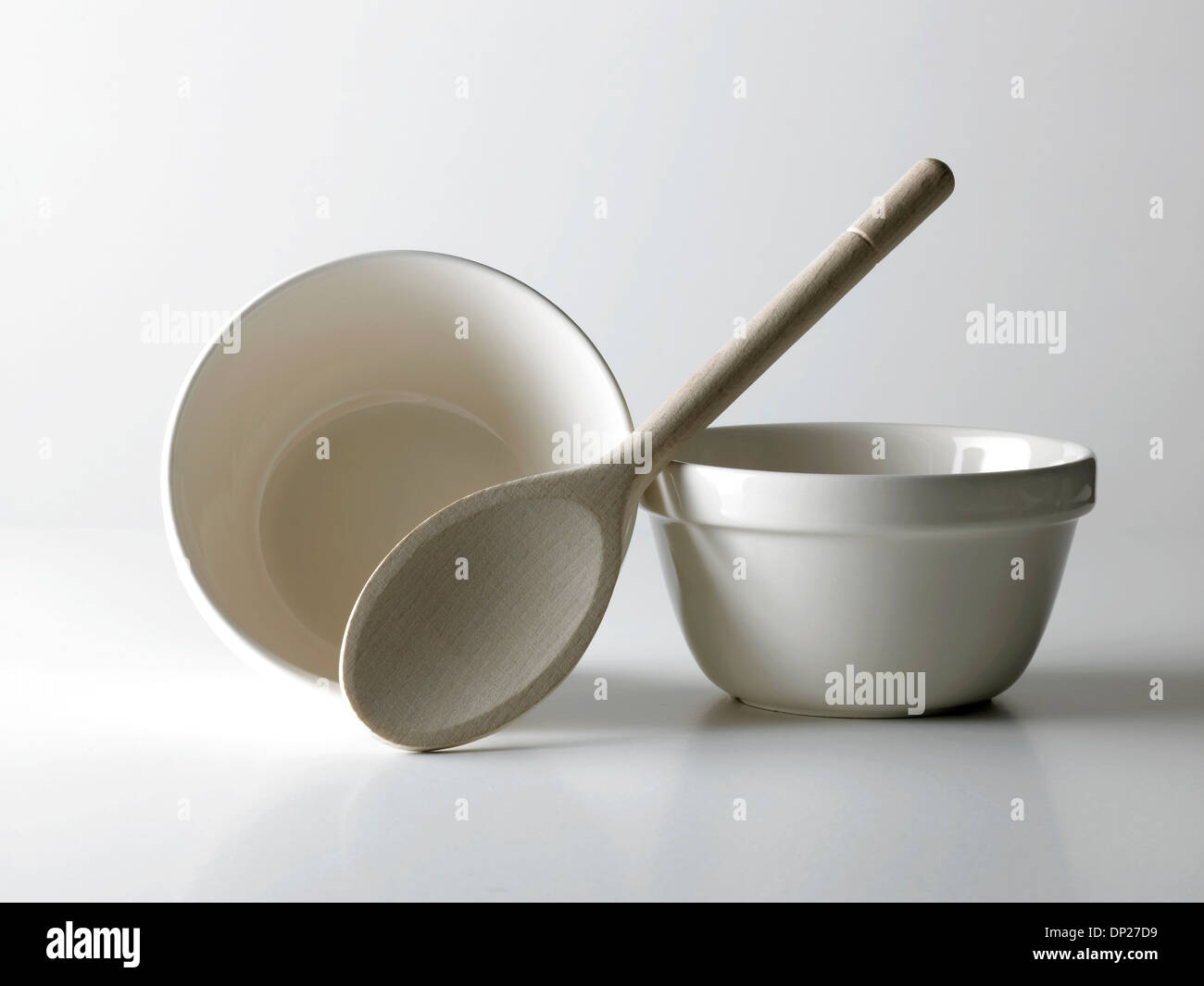 two white bowls and a wooden spoon Stock Photo