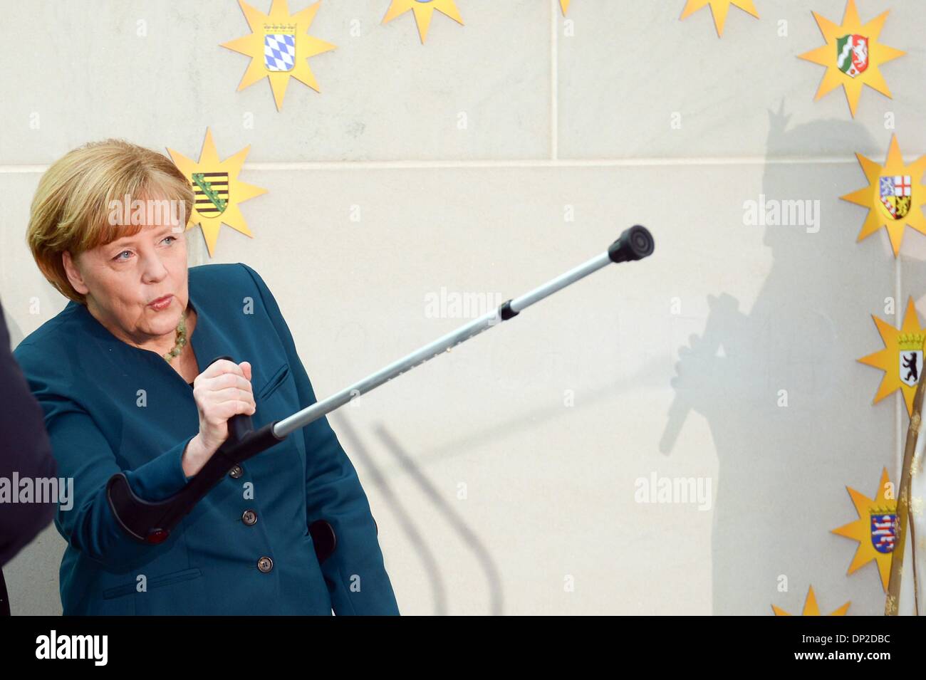 Berlin, Germany. 7th Jan, 2014. German Chancellor Angela Merkel uses crutches during the annual reception for Carolers at the chancellery in Berlin, Tuesday Jan. 7, 2014. German Chancellor Angela Merkel suffered a pelvis injury during ski holidays in the Swiss Alps and will have to cut back on her work schedule for the next three weeks. The signs show the different German cities the Carolers are coming from. Credit:  Goncalo Silva/NurPhoto/ZUMAPRESS.com/Alamy Live News Stock Photo
