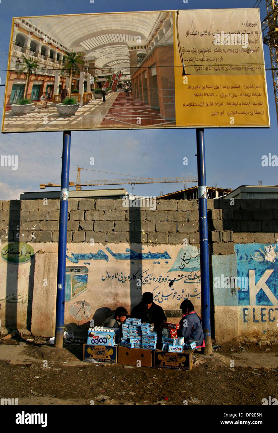 May 31, 2006; Arbil, Kurdistan, IRAQ; Children sell sweets underneath the billboard and the building site of the biggest shopping mall in the region that is under construction in the centre of Arbil, Iraqi Kurdistan, Jan 14, 2006. Due to a significantly better security than in the rest of the country, Iraqi Kurdistan experiences a construction boom using foreign and domestic compan Stock Photo