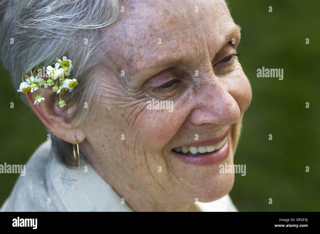 May 31, 2006; Sacramento, CA, USA; Betty Jensen of Auburn shows a bit of nature in her fashion by adoring her ear with a feverfew flower during an open house for the new location for the Sierra Nevada Conservancy in Auburn May 31, 2006.  Her husband, Everett, made a special oil painted portrait for the event.   Mandatory Credit: Photo by Autumn Cruz/Sacramento Bee/ZUMA Press. (©) C Stock Photo