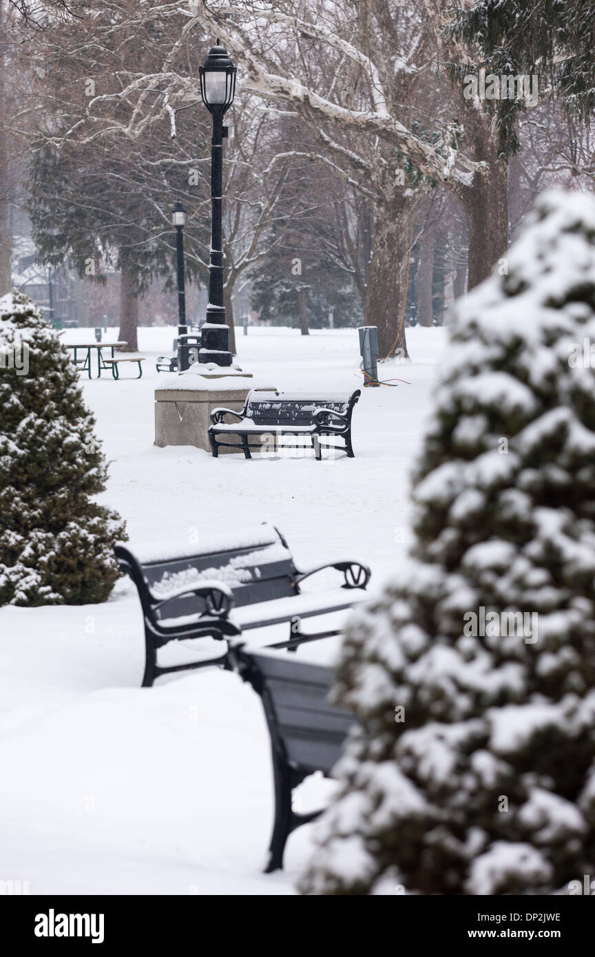 Recent snow fall covers trees, park benches and drinking fountains in Victoria Park. Stock Photo