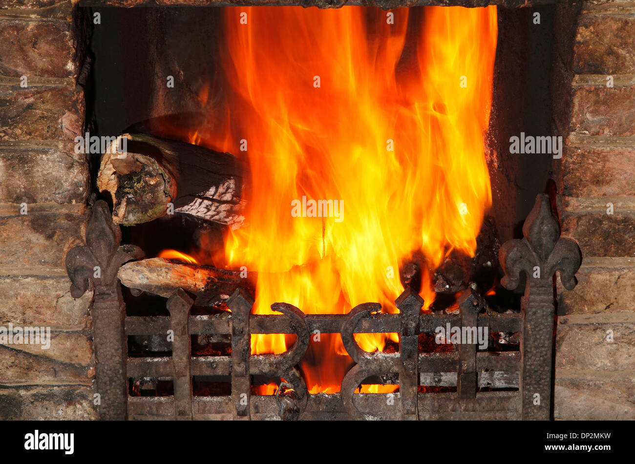 Fire in domestic hearth, heat flame flames heating fireside warmth fires grate burning wood coal home fires Stock Photo
