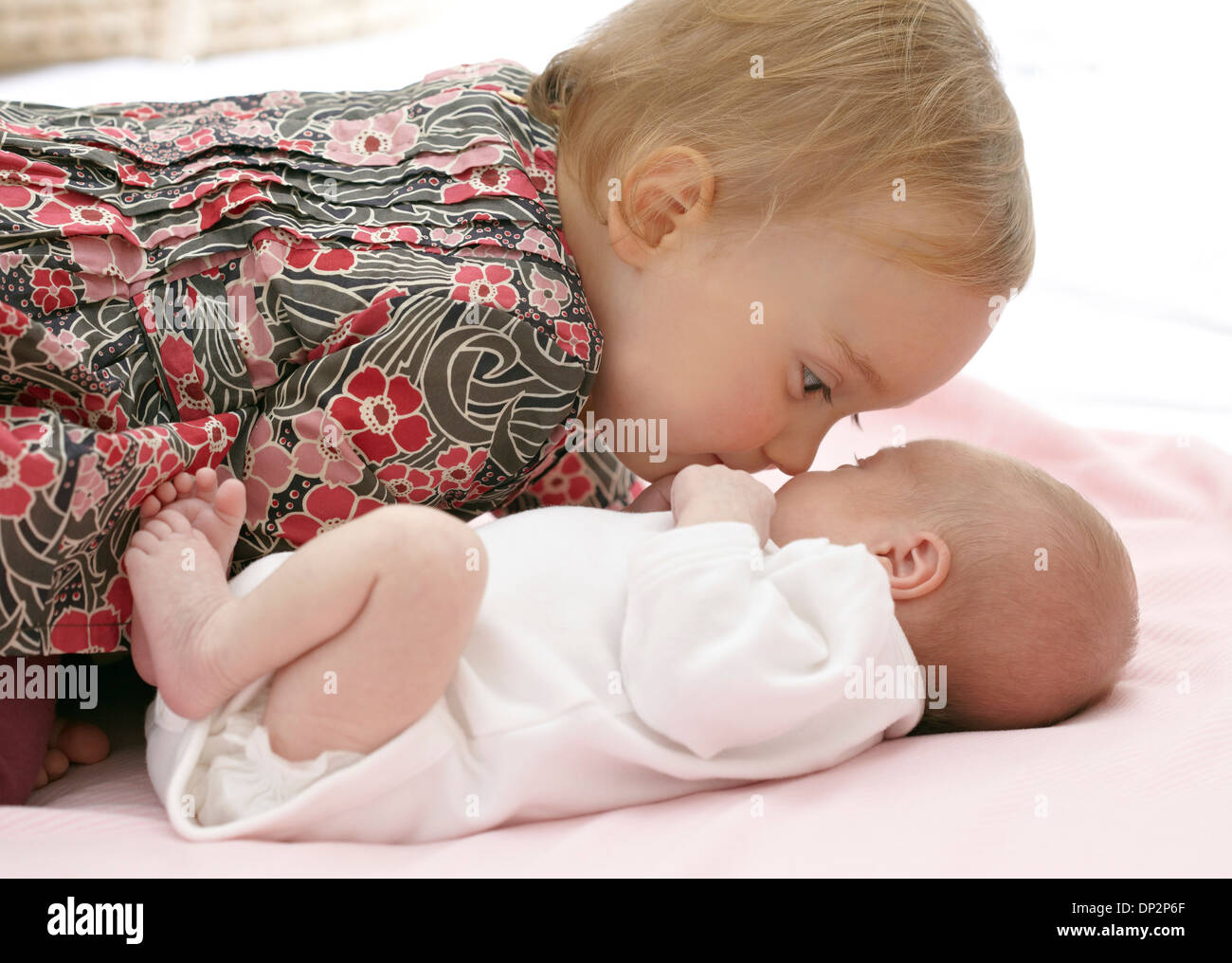 One year old girl with baby sister Stock Photo