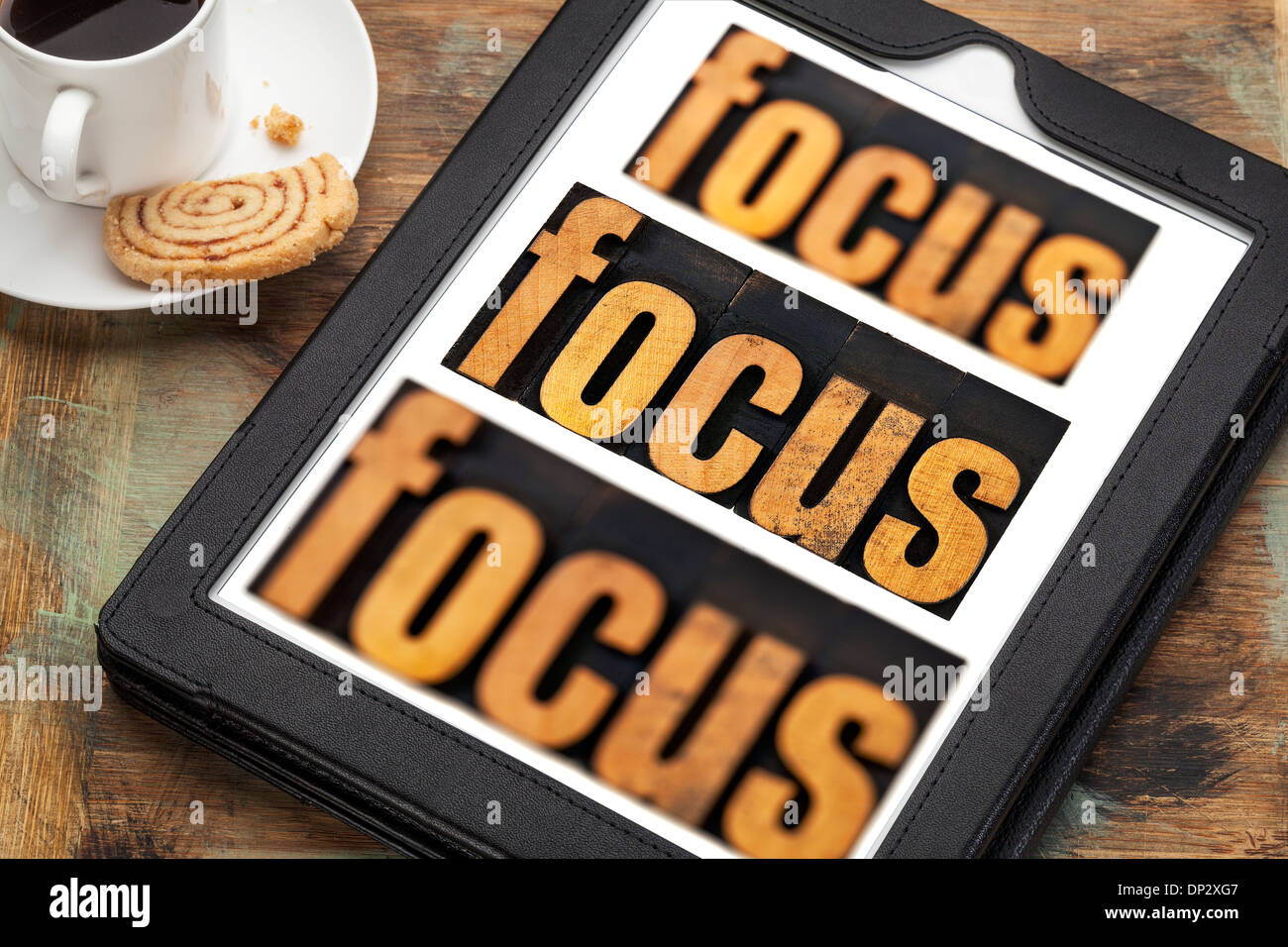 focus word in and out of focus - text in vintage letterpress wood type on a digital tablet with a cup of coffee Stock Photo