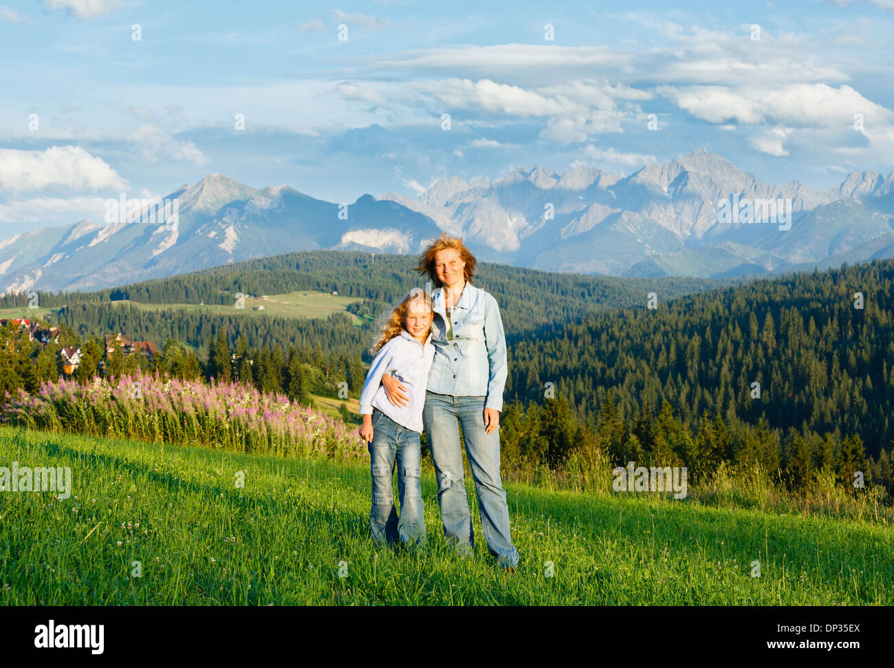Mother with daughter on summer hill and Tatra range behind (Gliczarow Gorny, Poland) Stock Photo