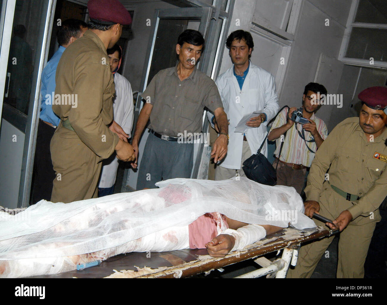 Jun 22, 2006; Spore, Kashmir, INDIA; Hospital staff and civilians rush a seriously wounded Kashmiri civilian for treatment to a local hospital, following a grenade blast in north Kashmir, in Srinagar, the summer capital of Indian Kashmir, 22 June, 2006. A hand grenade exploded Thursday during a sermon by a well-known Islamic religious leader addressing dozens of Muslim followers at Stock Photo