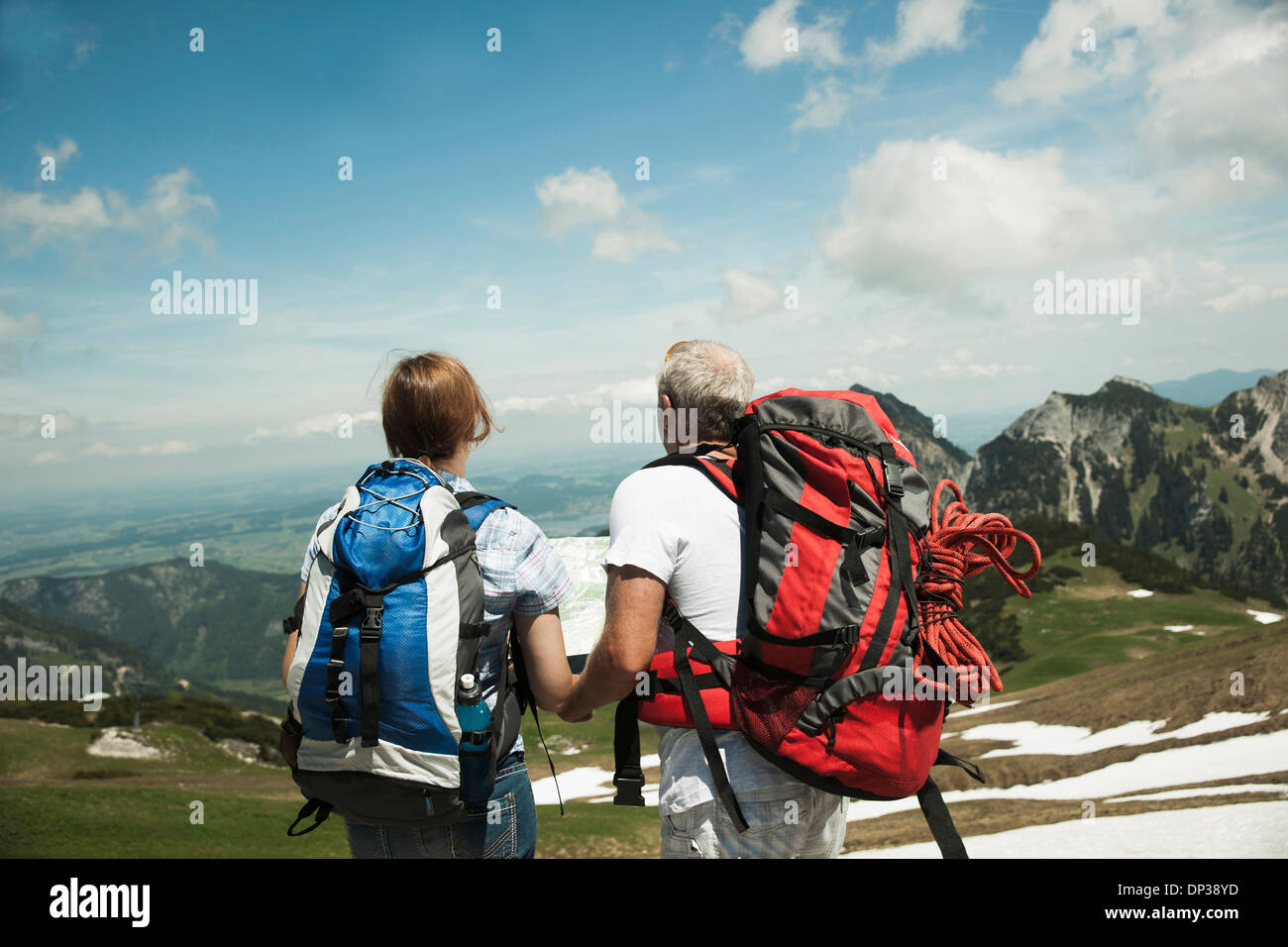 Backview of mature couple looking at map, hiking in mountains, Tannheim Valley, Austria Stock Photo