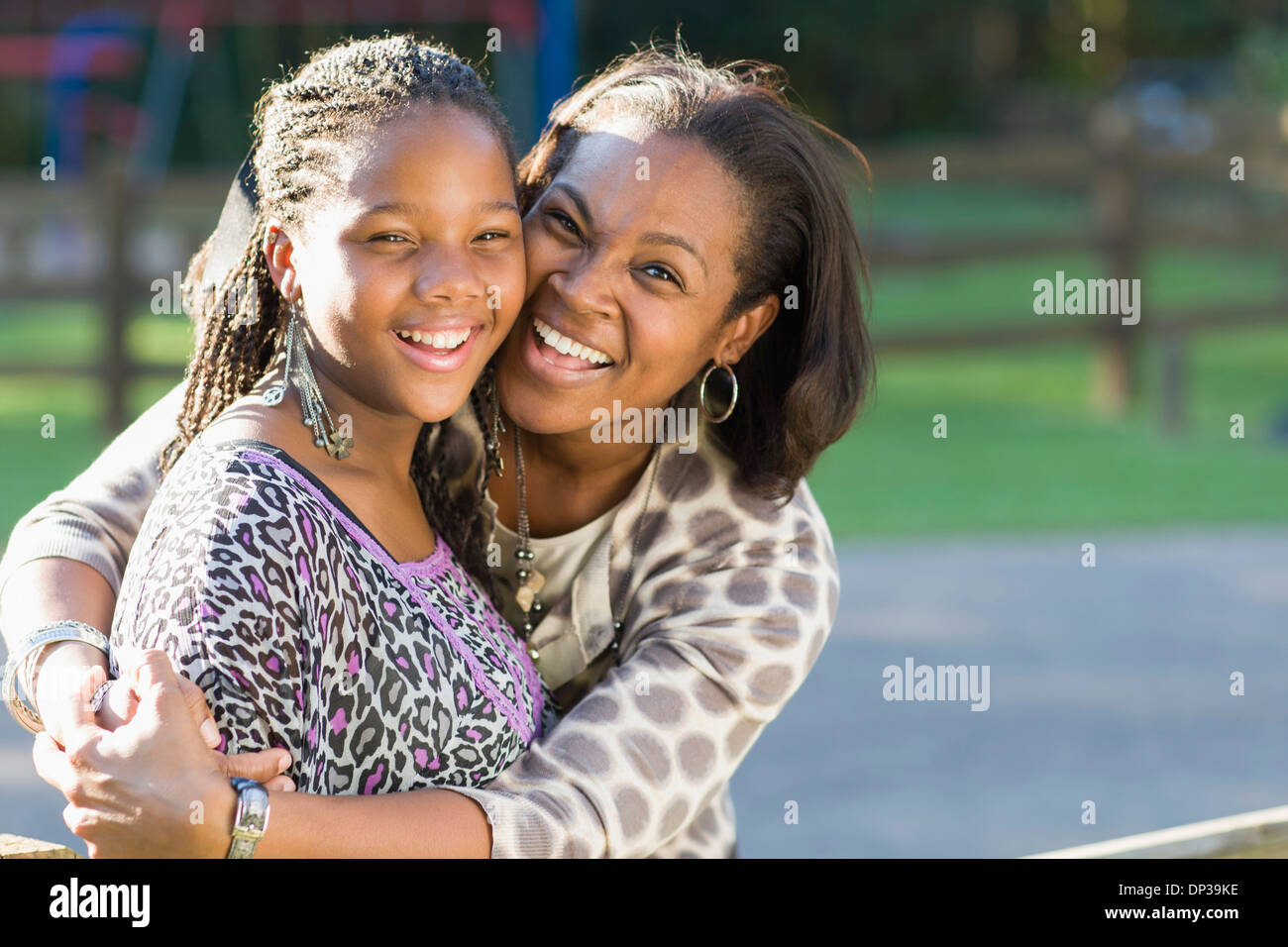 Portrait of pre-teen girl and mother, hugging outdoors Stock Photo
