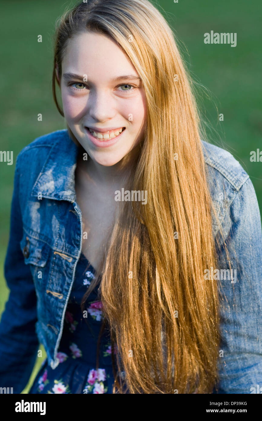 Portrait of pre-teen girl with long, blond hair, wearing jean jacket, outdoors Stock Photo