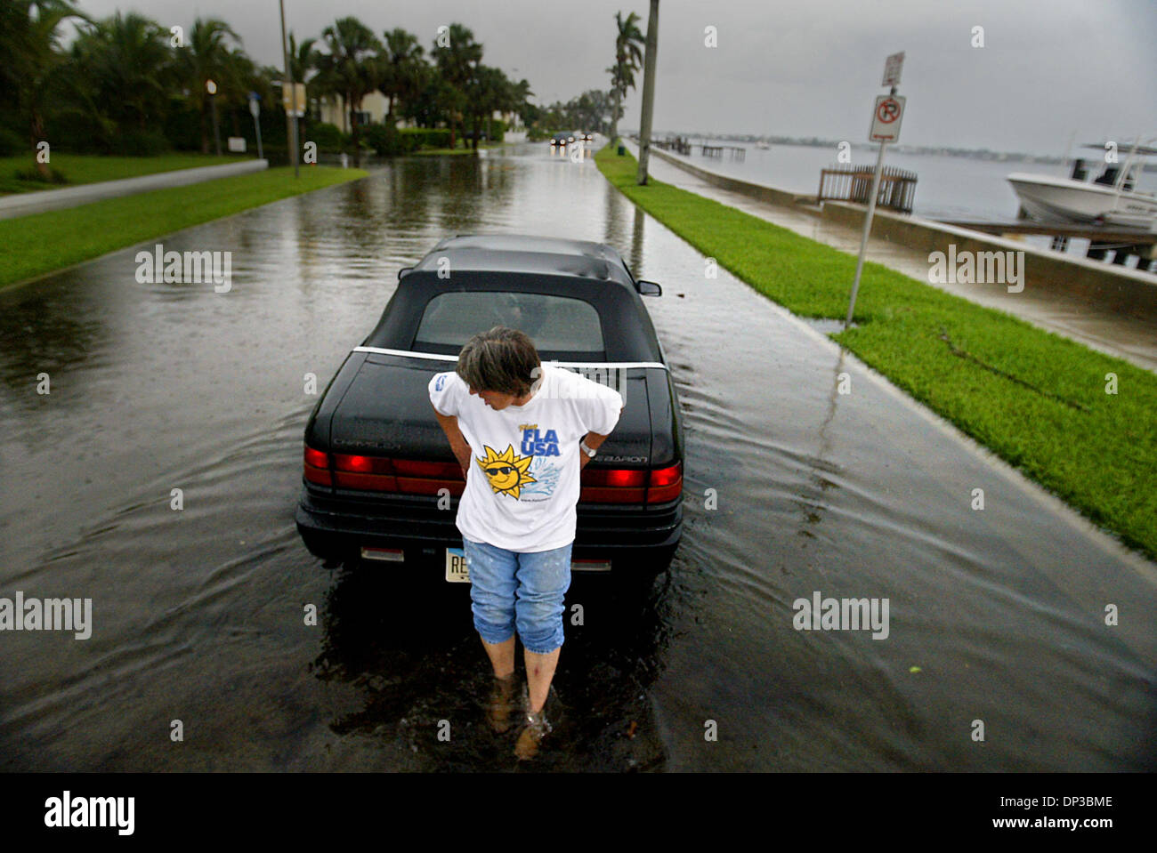 Jun 27, 2006; West Palm Beach, FL, USA; Following yesterday's afternoon downpours, Cathy Riegle of Hobe Sound struggles to push her friend Kaye Cooke in her Chrysler Lebaron down flooded Flagler Dr. just north of Southern Blvd.  Riegle had traveled to an appointment with Cooke and the two women were headed to find themselves some dinner in an area restaurant when Cooke's stalled.   Stock Photo