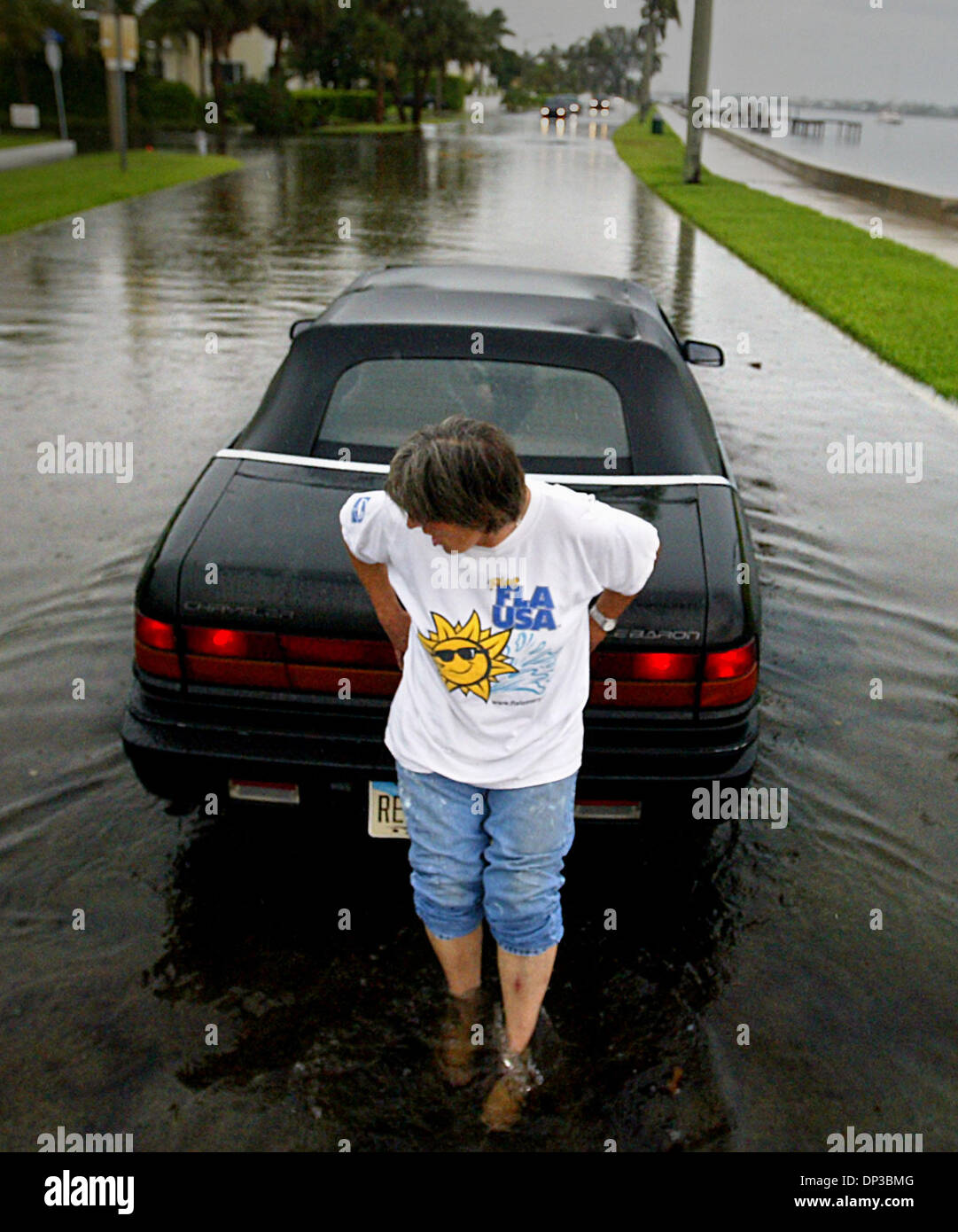 Jun 27, 2006; West Palm Beach, FL, USA; Following yesterday's afternoon downpours, Cathy Riegle of Hobe Sound struggles to push her friend Kaye Cooke in her Chrysler Lebaron down flooded Flagler Dr. just north of Southern Blvd.  Riegle had traveled to an appointment with Cooke and the two women were headed to find themselves some dinner in an area restaurant when Cooke's stalled.   Stock Photo