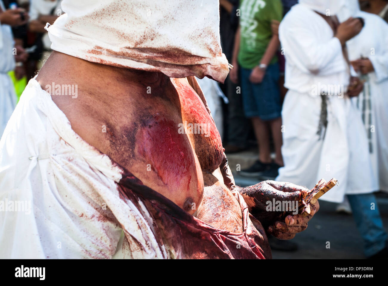 A penitent during the bloody procession for the Assumption of the Virgin Mary in Guardia Sanframondi, Campania, Italy Stock Photo
