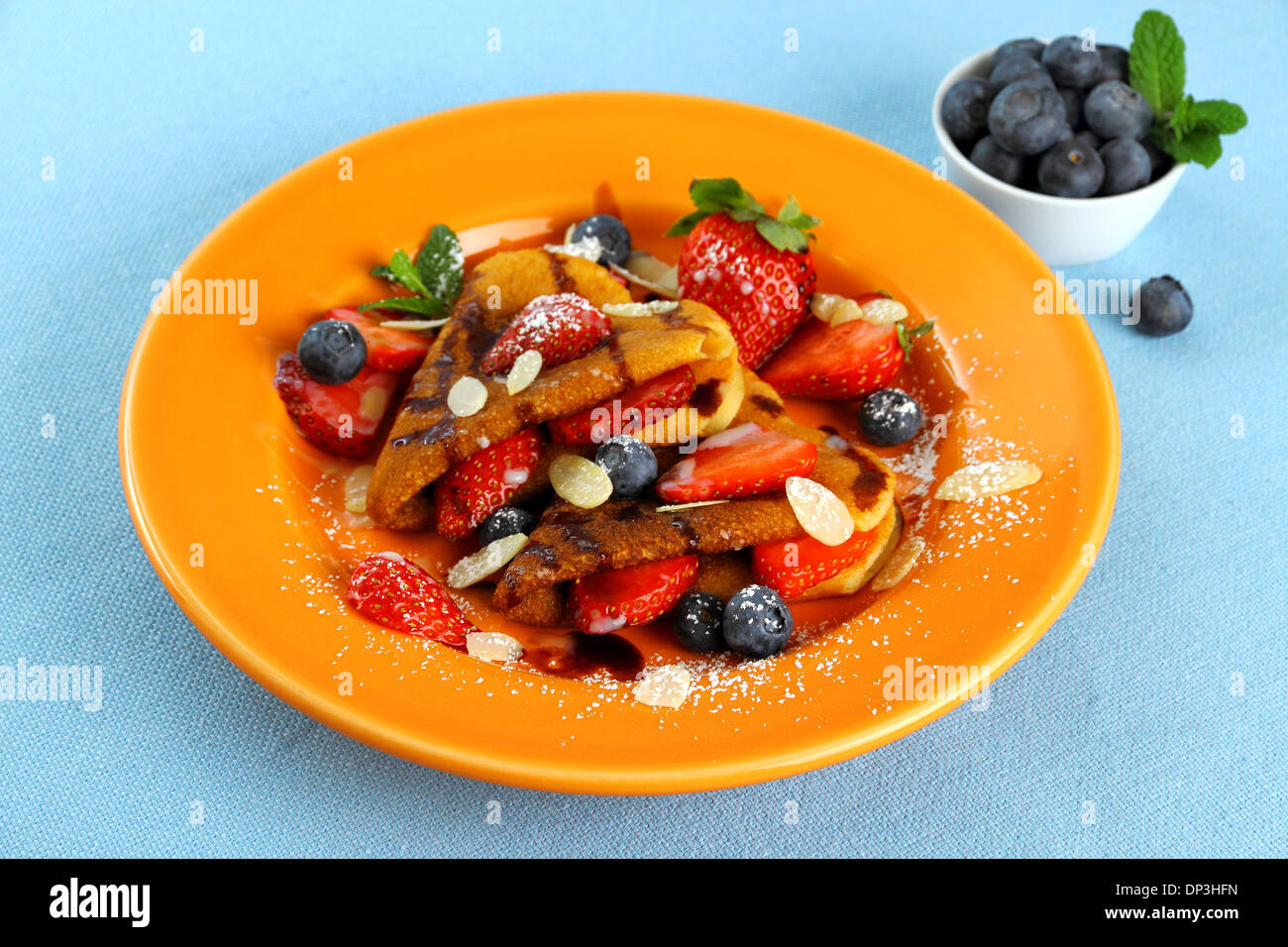 Two pancakes hearts with strawberry, blueberries and almond slivers Stock Photo