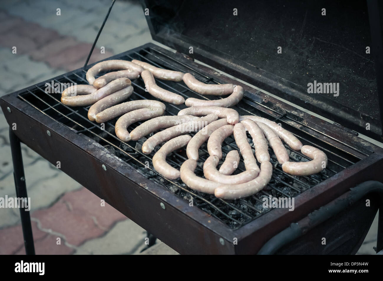 Meat sausages cooking on a charcoal grill in a garden Stock Photo Alamy