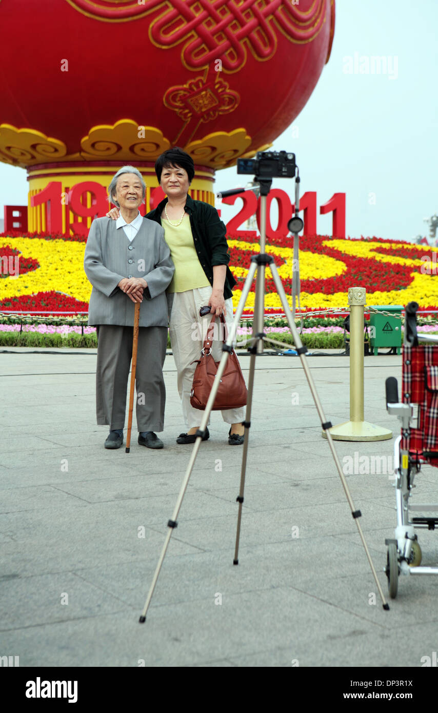 Old and young Chinese taking a self portrait in front of a communism commemorative display, Tiananmen Square, Beijing, China. Stock Photo