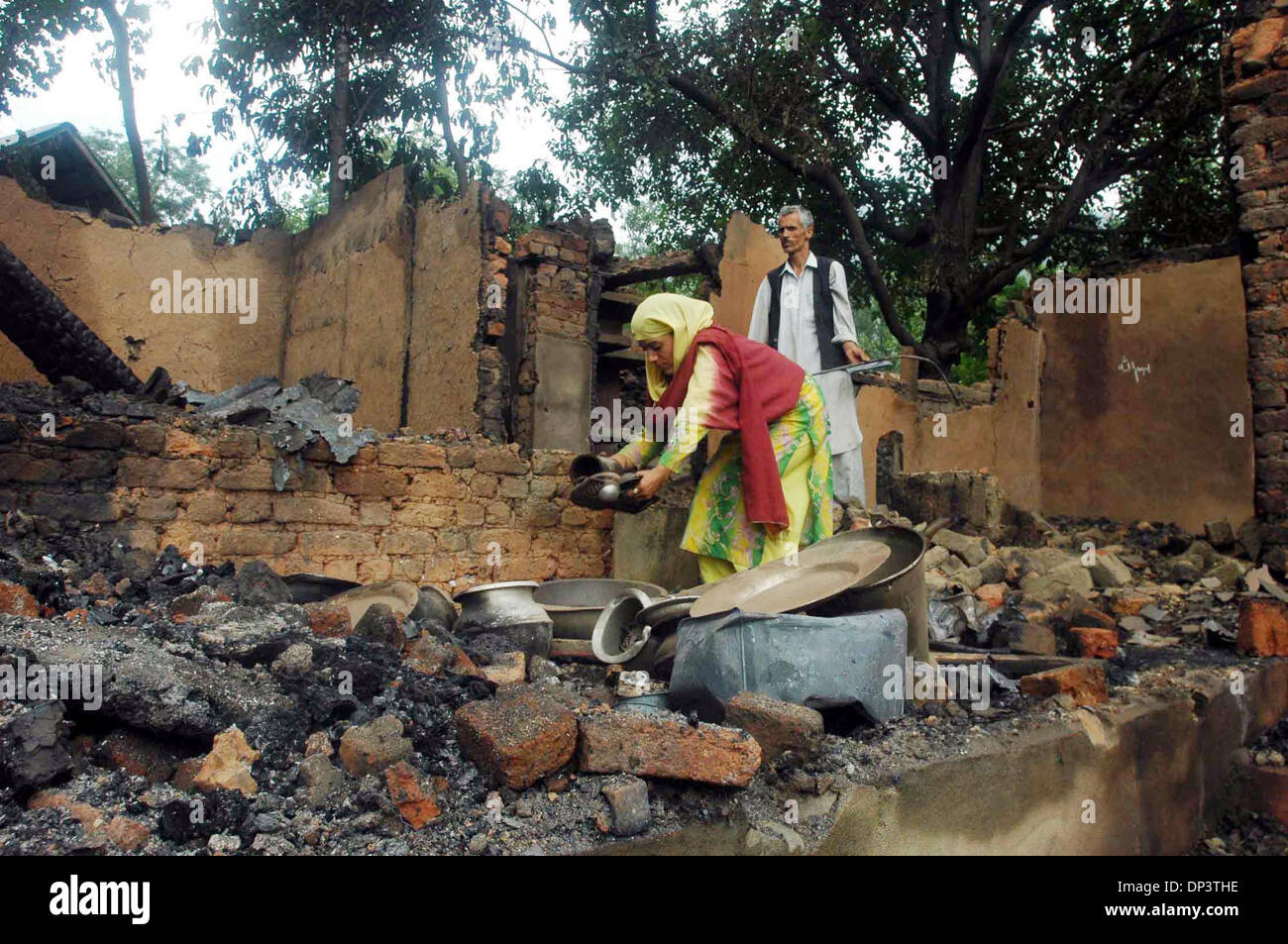 Jul 17, 2006; Bandipora, Kashmir, INDIA; A Kashmiri couple search through the debris of their house after a gun battle in Bandipora, 85 km (53 miles) north of Srinagar July 17, 2006. Two residential houses were completely destroyed during a gun battle between the suspected militants and Indian army in the area of Bandipora. Mandatory Credit: Photo by Altaf Zargar/ZUMA Press. (©) Co Stock Photo