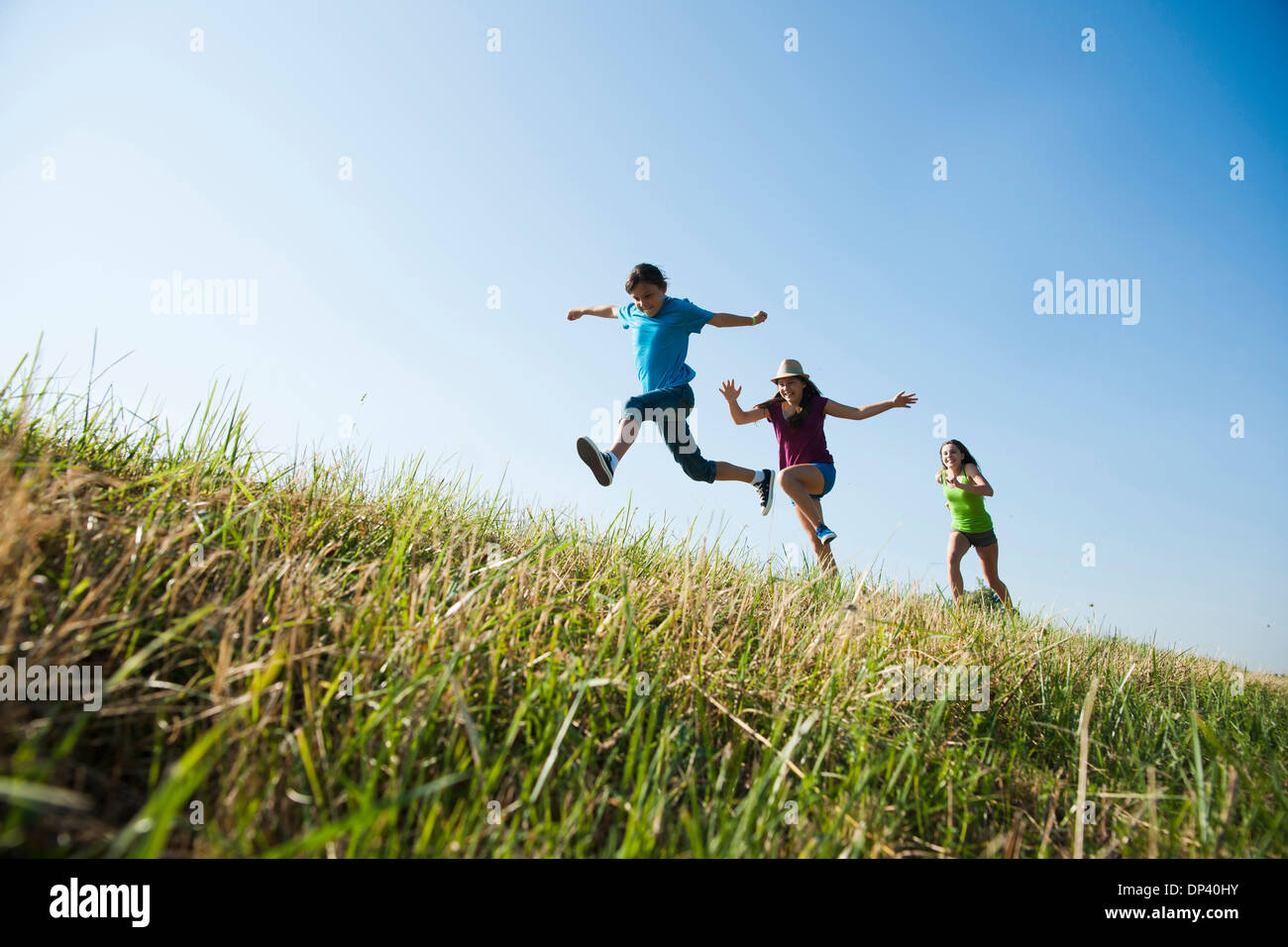 Girls running up hill, Germany Stock Photo